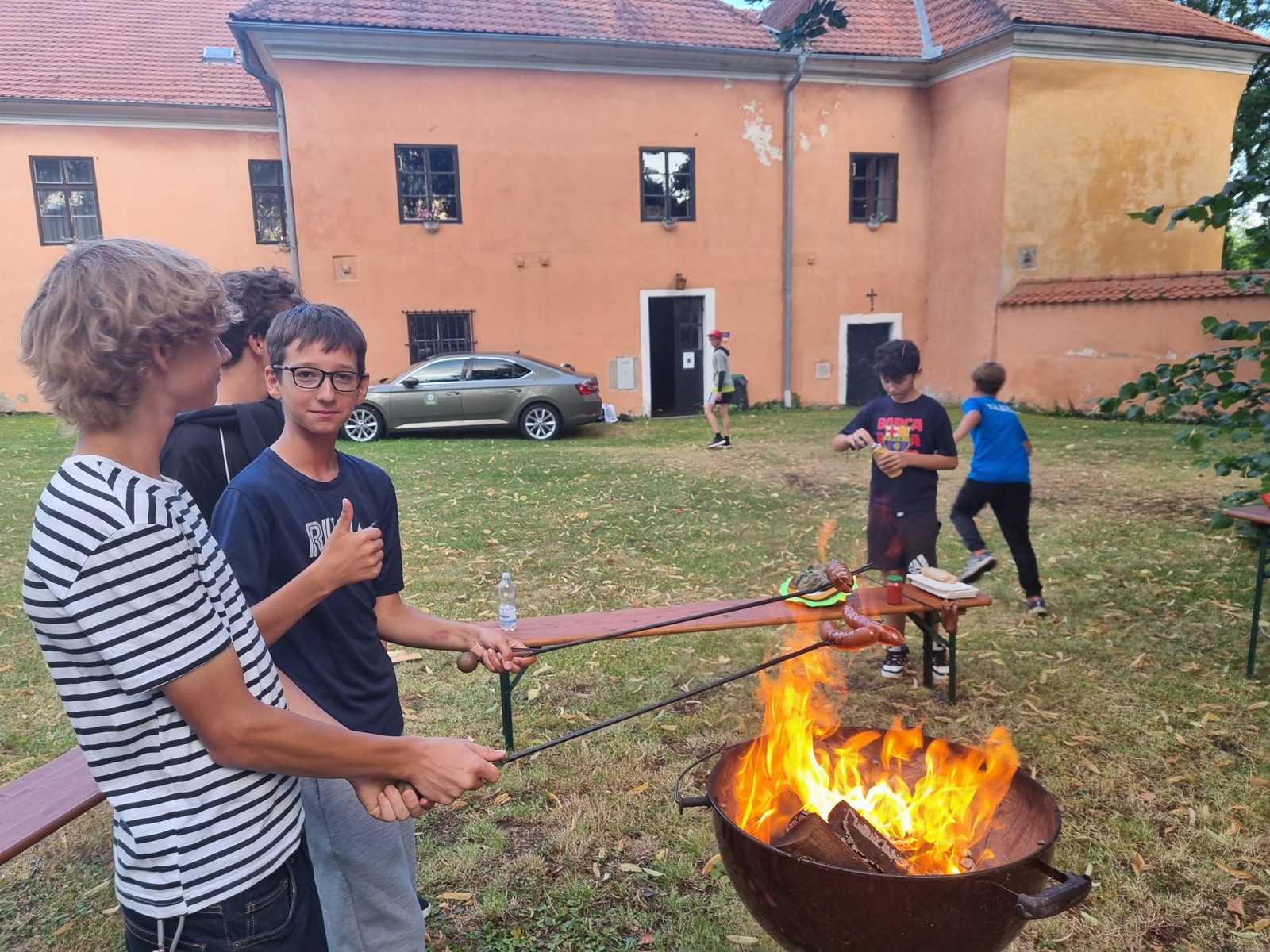 Děti opékají u ohně na zámku